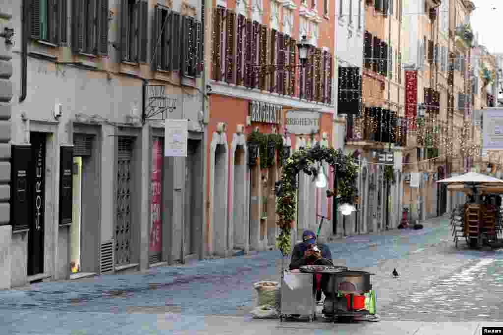 A street vendor sells roasted chestnuts on Via Frattina in Rome as Italy goes back to a complete lockdown during Christmas season as part of efforts put in place to curb the spread of the COVID-19.