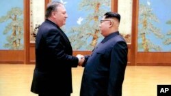 En esta imagen divulgada por la Casa Blanca, el secretario de Estado, Mike Pompeo saluda a Kim Jong Un durante su primera visita a Corea del Norte.