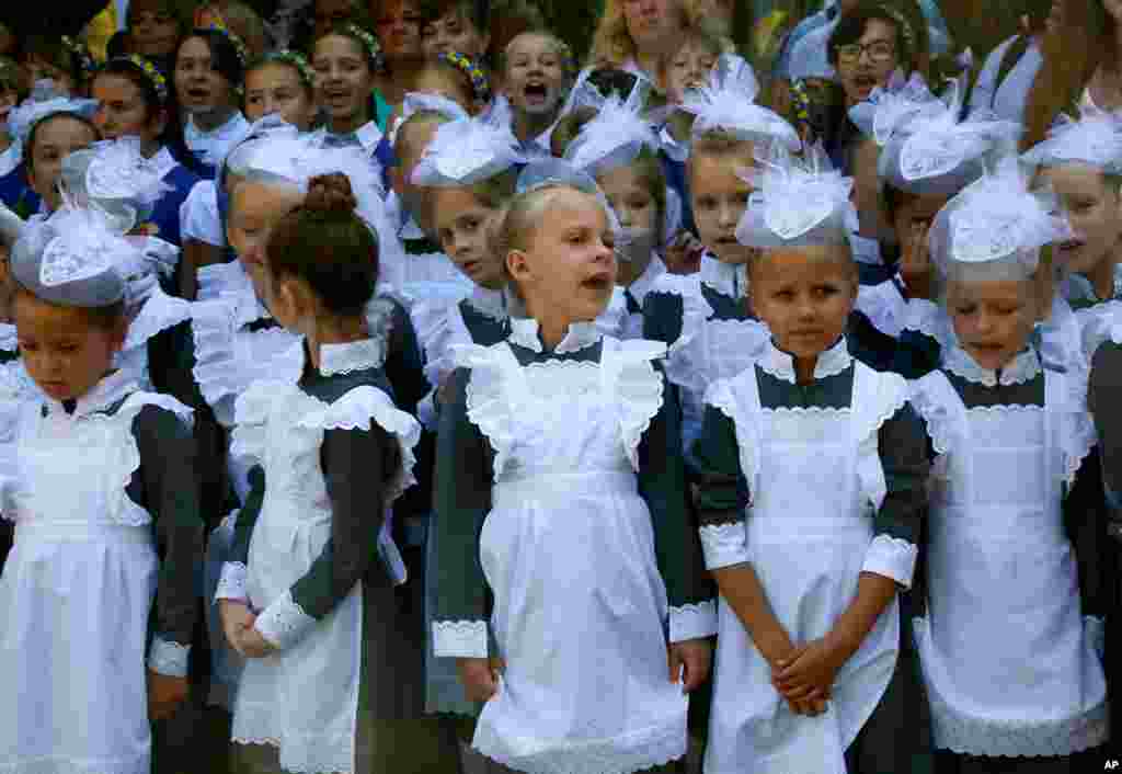 Schoolgirls in traditional uniforms attend a ceremony on the occasion of the first day of school at a cadet lyceum in Kyiv, Ukraine.