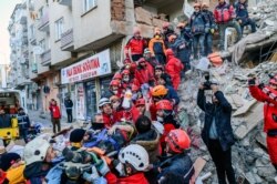 Rescue workers evacuate an injured woman from the rubble of a building after an earthquake in Elazig, eastern Turkey, Jan. 25, 2020.