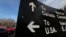 FILE - A sign giving directions is seen in the parking lot of the United States-Canada border in Surrey, British Columbia, Feb. 16, 2017. 