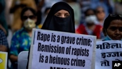 FILE-A Muslim woman holds a placard against remission of sentence by the government to men convicted of a gang rape of a Muslim woman in communal violence in 2002 in western Gujarat state, during a protest in New Delhi, India, Aug. 27, 2022.