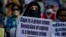 FILE-A Muslim woman holds a placard against remission of sentence by the government to men convicted of a gang rape of a Muslim woman in communal violence in 2002 in western Gujarat state, during a protest in New Delhi, India, Aug. 27, 2022.
