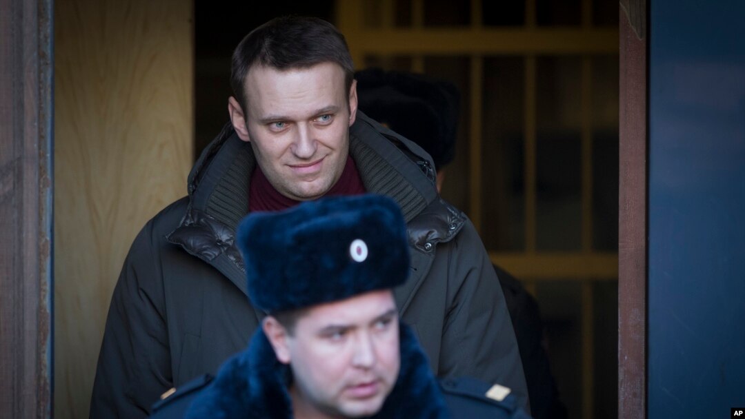 Pemimpin oposisi Rusia Alexei Navalny, tampak berada di belakang polisi yang menjaganya setelah ia meninggalkan ruang sidang di pengadilan Moskow (25/2). 