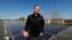 Todd Miller stands next to solar panels on the roof of his solar installation business in Ankeny, Iowa, April 15, 2019.