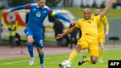 Pemain Islandia, Gylfi Thor Sigurdsson (kiri) dan Vincent Kompany dari Belgia berebut bola dalam laga UEFA Nations League antara Islandia dan Belgia di Reykjavik, Islandia, 11 September 2018.