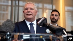 ARCHIVO - El primer ministro de Ontario, Doug Ford (c), habla a los periodistas mientras Stephen Lecce (d), ministro de Energía y Electrificación de Ontario, escucha después de un evento con la Cámara de Comercio de EEUU, el martes 11 de febrero de 2025, en Washington. 