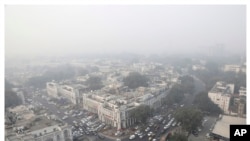 This combination of Nov. 1, 2019, top, and April 20, 2020 photos shows New Delhi's skyline. India's air quality improved drastically during a nationwide lockdown to curb the COVID-19 coronavirus.