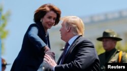 Presiden AS Donald Trump berjabat tangan dengan Ketua DPR Nancy Pelosi ketika mereka menghadiri Layanan Peringatan Perwira Perdamaian Nasional Tahunan ke-38 di Capitol Hill di Washington, AS, 15 Mei 2019. (Foto: Reuters/Carlos Barria)