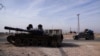 A van loaded passes an abandoned tank in Aleppo, Syria, days after rebels seized the capital Damascus and ousted Syria's Bashar al-Assad, Dec. 11, 2024. 