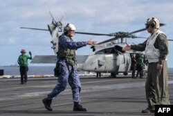 Laksamana Muda AS Christopher Alexander (kiri), komandan Carrier Strike Group 9, tiba di atas kapal induk USS Carl Vinson selama latihan maritim tiga hari AS dan Jepang di Laut Filipina, 31 Januari 2024. (Richard A. Brooks / AFP)