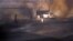 Masked Bahraini anti-government protesters run through smoke after setting tires alight on a road in the village of Dumistan, January 7, 2013.