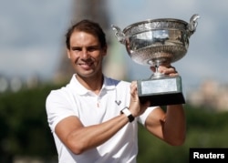 Rafael Nadal de España posa en el puente Alexandre III frente a la Torre Eiffel con el trofeo después de ganar el título masculino del Abierto de Francia.  (REUTERS/Benoit Tessier)