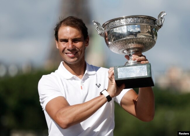 Spain's Rafael Nadal poses on the Alexandre III bridge in front of the Eiffel Tower with the trophy after winning the men's singles French Open title. (REUTERS/Benoit Tessier)