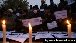 Family members of two civilians who died during a search operation by government forces demand, along with others, justice and the return of the bodies of their loved ones, during a protest in Srinagar, Indian-administered Kashmir, Nov. 17, 2021.