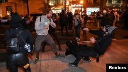 A supporter of U.S. President Donald Trump fights with counter protesters during a march in response to various pro-Trump rallies held throughout D.C., in Washington, Dec. 12, 2020.