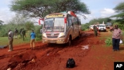 FILE - Kenyan security forces and others gather near the scene of a deadly bus attack 50 kilometers (31 miles) outside the town of Mandera, near the Somali border in northeastern Kenya, Nov. 22, 2014.