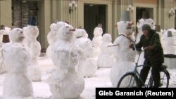 Seorang pria mengendarai sepedanya di antara patung salju yang dipasang di Moskow sebagai ilustrasi. Seorang pria Rusia menciptakan kendaraan seperti sepeda biasa tetapi dengan sedikit modifikasi untuk musim salju. (Foto: REUTERS/Gleb Garanich)