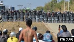 Riot police stand guard near a prison during a demonstration by protesters against the military coup in Naypyidaw on February 15, 2021. (Photo by STR / AFP)