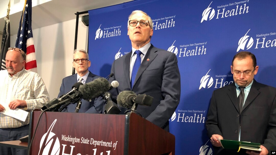 Washington Gov. Jay Inslee, center, speaks Tuesday Jan. 21, 2020, at a news conference in Shoreline, Wash., following the announcement that a man in Washington state is the first known person in the United States to catch a new type of coronavirus. (AP Photo/Carla K. Johnson)