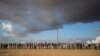 FILE - African asylum seekers, who entered Israel illegally via Egypt, lean at the fence of the Holot detention center in Israel's southern Negev Desert, on Feb. 17, 2014 as they join other migrants who came to protest outside the detention facility. 