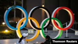 Olympic rings are seen near the National Stadium in Tokyo. Japan is publicly adamant that it will stage its postponed Olympics this summer.