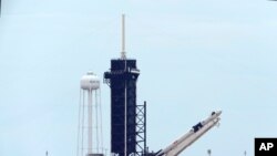 The SpaceX Falcon 9, with the Dragon capsule on top of the rocket, is raised onto Launch Pad 39-A, May 26, 2020.