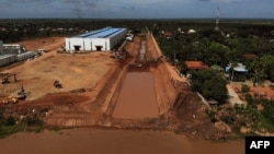 This aerial photo taken on July 9, 2024 shows workers using excavators to dig the Funan Techo canal along the Prek Takeo channel that runs into the Mekong River (bottom) in Kandal province.