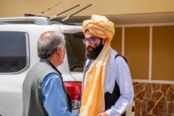 In this photo released by the Taliban, senior Haqqani group leader Anas Haqqani (R) speaks to Abdullah Abdullah, head of Afghanistan's National Reconciliation Council and former government negotiator with the Taliban, in Kabul, Aug. 18, 2021.