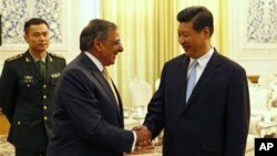 Menteri Pertahanan AS, Leon Panetta (kiri) berjabat tangan dengan bakal pemimpin tertinggi Tiongkok, Xi Jinping di Beijing (19/9). 