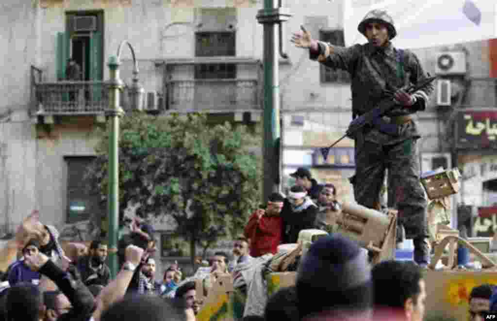 An Egyptian soldier atop an armored personnel carrier tries to clam down anti-government demonstrators, who charged to clash with pro-government protesters in Tahrir square, in Cairo, Egypt, Wednesday, Feb. 2, 2011. Several thousand supporters of Presiden