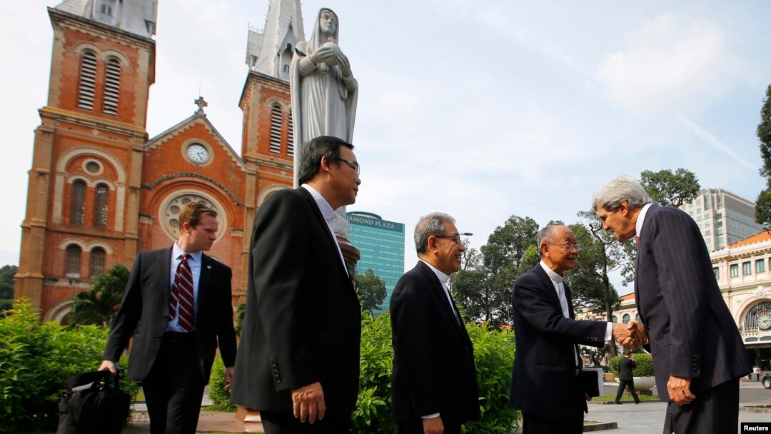 Menlu AS John Kerry (kanan) disambut para pastor Vietnam saat hendak mengikuti misa di Katedral Notre Dame di kota Ho Chi Minh (14/12).