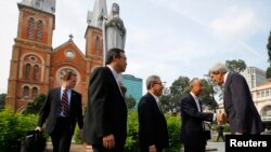 Menlu AS John Kerry (kanan) disambut para pastor Vietnam saat hendak mengikuti misa di Katedral Notre Dame di kota Ho Chi Minh (14/12).