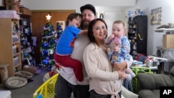 Steve Petersen, second from left, his wife Jennifer, and their children Jerrik, left, and Carolynn, are photographed at their two-bedroom apartment in Campbell, California, Jan. 15, 2025. 