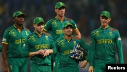 South African players Quinton de Koc, David Miller and teammates walking off the field after their loss to Australia at the 2023 Cricket World Cup in India