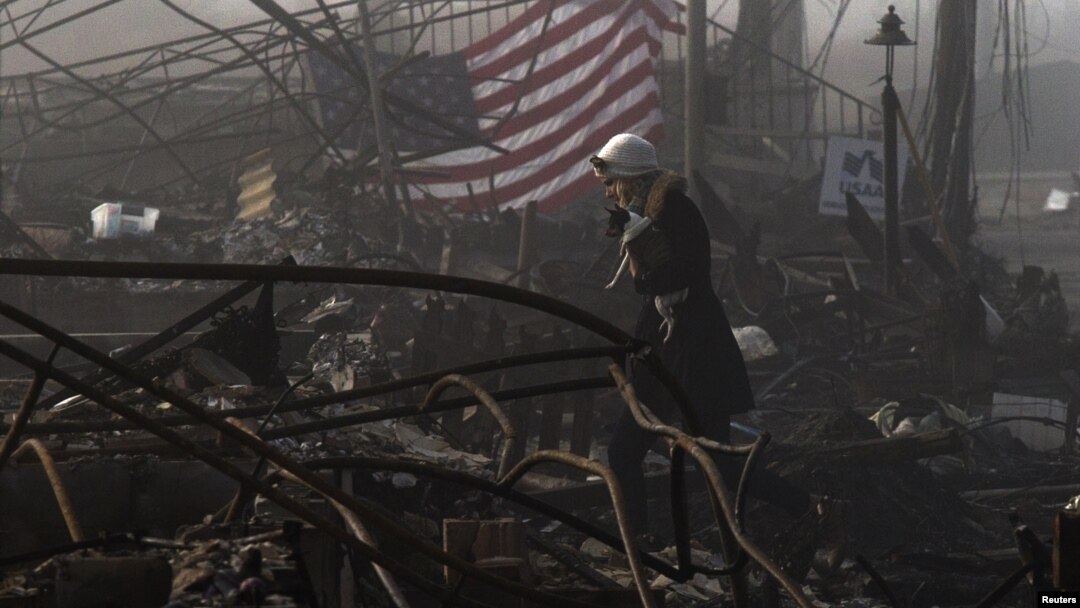 Seorang warga New York berjalan di antara puing-puing rumah yang hancur oleh Badai Sandy. (Foto: Dok)