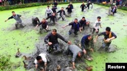 Des villageois attrapent des canards lors d’un festival traditionnel de l’ethnie Miao, à Jianhe, dans la province du Guizhou, Chine, 24 mars 2016.