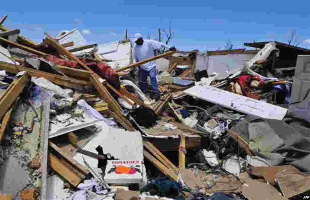 Thomas Dickerson looks for his belongings in the remains of his apartment in the Alberta City neighborhood Thursday April 28, 2011, after a tornado struck Tuscaloosa, Ala. the day before. Massive tornadoes tore a town-flattening streak across the South, k