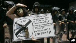 Una mujer porta un cartel contra el aumento de la violencia en el país durante una manifestación en Caracas.