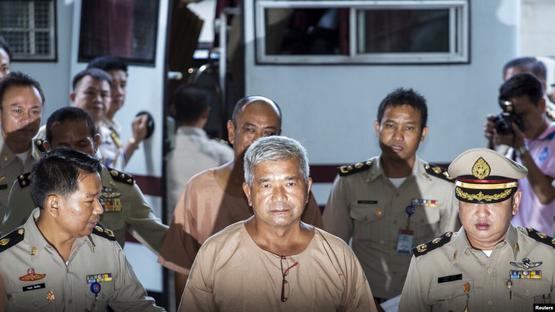 FILE - Lieutenant-General Manas Kongpaen (C) is escorted by officers as he arrives at the criminal court in Bangkok, Thailand, Nov. 10, 2015. 