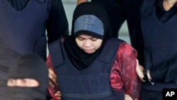 Indonesian Siti Aisyah is escorted by police as she leaves after a court hearing at Shah Alam High Court in Shah Alam, Malaysia, March 22, 2018. Aisyah and Doan of Vietnam have pleaded not guilty of killing Kim Jong Nam on Feb. 13, 2017 at a crowded Kuala Lumpur airport terminal.