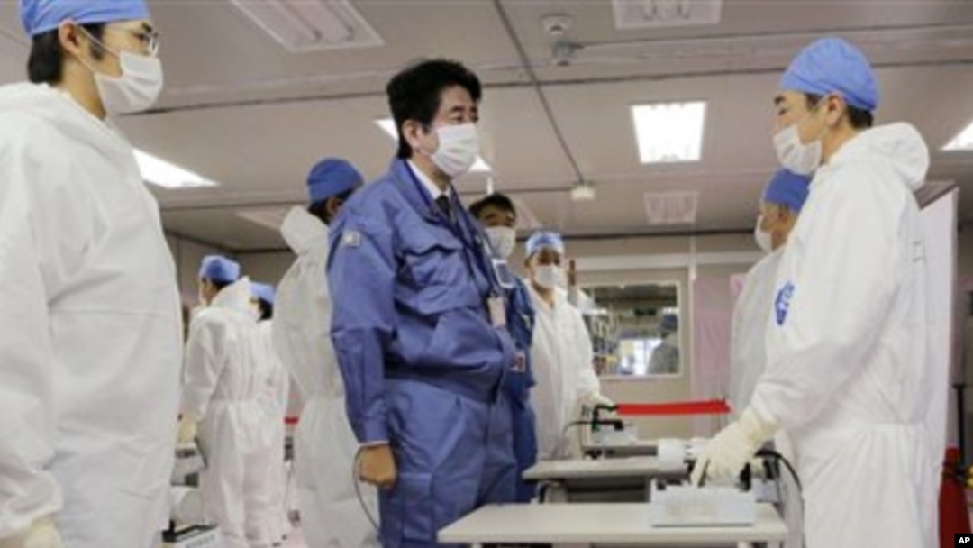 Perdana Menteri baru Jepang, Shinzo Abe (tengah), berbincang dengan pekerja di Pusat Operasi Darurat Tokyo Electric Power Co.(TEPCO) di PLTN Okuma, Fukushima, Jepang (29/12).