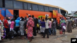 FILE - People board a commercial bus to flee after attacks by Boko Haram in Bama and other parts of Maiduguri, Nigeria, Sept. 8, 2014. 