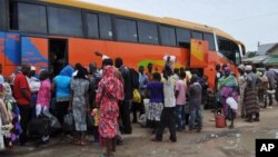 FILE - People board a commercial bus to flee following attacks by Boko haram in Bama and other parts of Maiduguri, Nigeria, Sept. 8, 2014. 