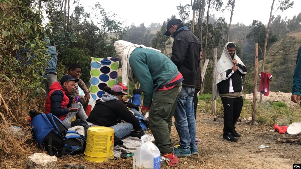 Un grupo de venezolanos espera mientras la frontera para Ecuador abre para ellos, tratan de mantenerse abrigados en medio del frÃo y se ayudan para poder comer. Ipiales, Colombia, 11 de septiembre de 2019. Foto: Celia Mendoza - VOA.