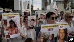 FILE - Relatives and friends of hostages held in the Gaza Strip by the Hamas militant group call for their release during the Jewish holiday of Hanukkah in the Hostages Square at the Museum of Art, in Tel Aviv, Israel, December 8, 2023.