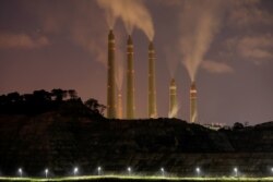 FILE PHOTO: Smoke and steam billows from the coal-fired power plant owned by Indonesia Power, next to an area for Java 9 and 10 Coal-Fired Steam Power Plant Project in Suralaya