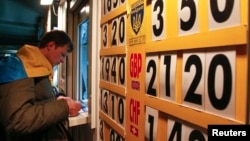 FILE - A man exchanges money at a currency exchange office in Kyiv April 10, 2014.
