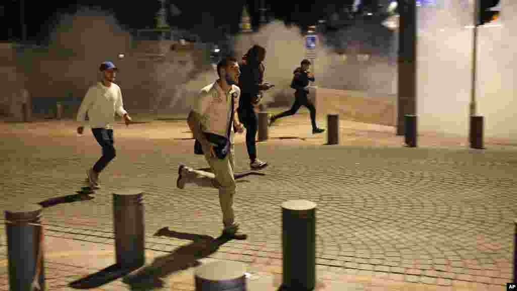 Des fans courent dans les rues de Marseille, après que la police a tiré des gaz lacrymogènes, le 11 juin 2016.