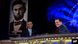 Presiden AS Barack Obama berbincang dengan komedian dan pembawa acara Stephen Colbert dari program televisi The Colbert Report during a taping of The Colbert Report di George Washington University, Washington, 2014.